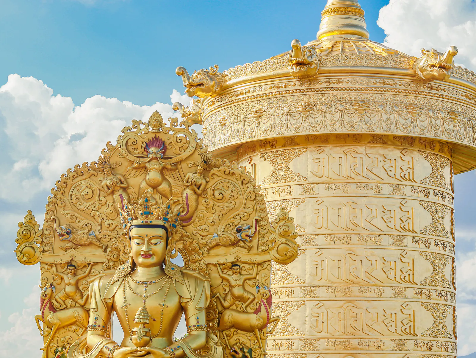 Tượng Phật bằng đồng vàng đội mũ báu đặt cạnh Đại bảo tháp Kinh Luân khắc chú Om Mani Padme Hum ở Samten Hills Đà Lạt
