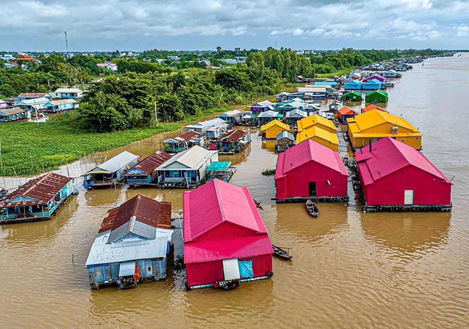 Những dãy nhà bè sơn đỏ, vàng, xanh nổi trên khúc sông nước phù sa, nhìn từ trên cao